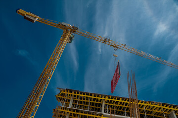 Wooden beams and a crane in a residential building on the background of the sky