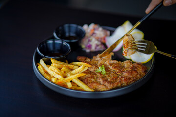 Grilled chicken breast, French fries and vegetables stock photo