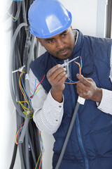 male electrician testing wires with screwdriver
