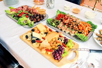 Gedeckter Tisch mit Buffet, leckere Vorspeisenplatten mit Antipasti und Häppchen