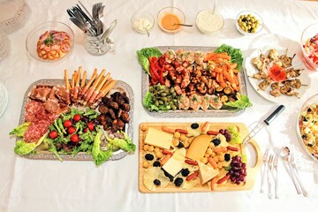 Gedeckter Tisch mit Buffet, leckere Vorspeisenplatten mit Antipasti und Häppchen