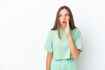 Young Lithuanian woman isolated on white background whispering something with surprise gesture while looking to the side