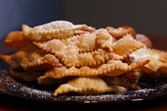 Frappe or chiacchiere and onbaked castagnole typical Italian carnival fritters dusted with powdered sugar. Biscuits with sugar for the carnival of Venice. Traditional sweet pastries