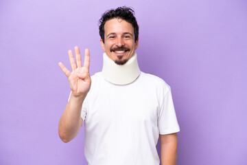 Young caucasian man wearing neck brace isolated on purple background happy and counting four with fingers