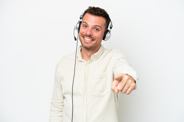 Telemarketer caucasian man working with a headset isolated on white background points finger at you with a confident expression