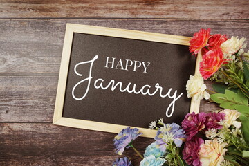 Hello January typography text and flower decoration on blackboard background