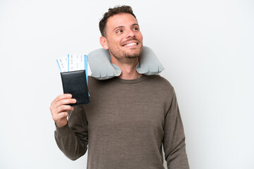 Young caucasian man holding a passport isolated on white background thinking an idea while looking up