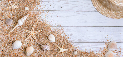 Obraz na płótnie Canvas Sand seashells baner background. Summer time concept with sea shells and starfish on wooden background and sand