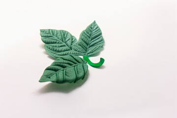 green hyper-realistic floral hand-made plasticine flowers or play-doh spring leaves and foilage with stems, isolated on white background (generative ai)