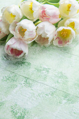 Bouquet of pink tulips on green wooden background. Spring holidays background. Space for text. Flat lay.