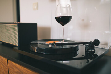 Glass of red wine swirling on the spinning gramophone record