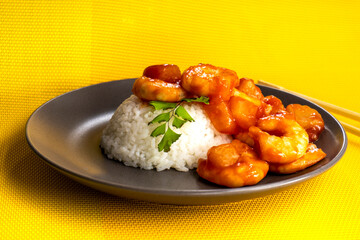 Shrimp in sweet and sour sauce with rice on a yellow background. food concept. diet. chinese recipe
