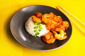 Shrimp in sweet and sour sauce with rice on a yellow background. food concept. diet. chinese recipe
