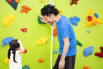 Fototapeta premium 体操クラブなどでボルダリングをする子供と先生