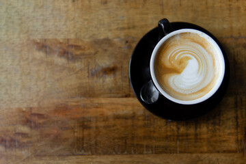 everyday coffee. close-up cappuccino with blurred wooden table background.