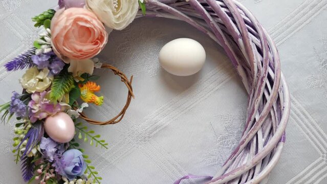 The egg is turned in the middle of a festively decorated wreath. Slow motion. Vertical video. Easter celebration. Happy Easter.
