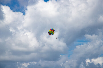 parasailing against blue sky rainbow colors