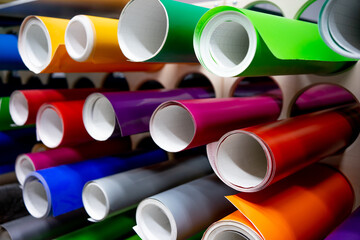 A roll of vinyl self-adhesive film on the shelf. Film for visual tuning of the car. Multi-colored...