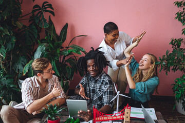Diverse group of international students working on the urban project of modern city with renewable energy source, green areas. Concept of ecology, environment protection, waste recycling, technology