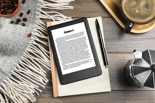 Flat lay composition with portable e-book reader and notebook on wooden table