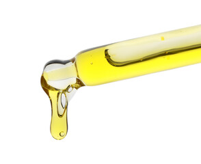 Dripping yellow facial serum from pipette on white background, closeup