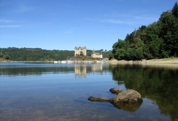  Château de Val se reflétant dans les eaux calmes du lac de Bord-Les-Orgues à Lanobre, France. 