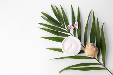 Jar of cream, shells, quartz gemstone and palm leaf on white background, flat lay. Space for text
