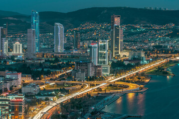 Fototapeta na wymiar View of izmir city with high buildings and roads with car lights and evening light of city