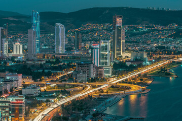 Obraz premium View of izmir city with high buildings and roads with car lights and evening light of city