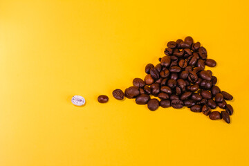 coffee beans are black and one bean is white, one is different from all, many objects, not like everyone else, lie on the surface of the yellow background. concept leader team success.