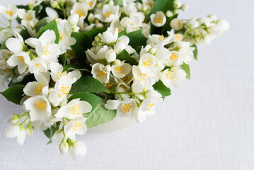 Beautiful white jasmine flowers on a table on a white tablecloth. copy space for wedding, birthday, party or other celebration.
