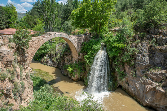 View of Clandras bridge of Usak province with green nature and river and waterfall with blue cloudy sky