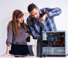 Two repairmen repairing desktop computer