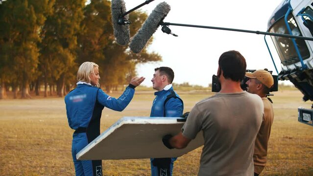 The girl slapped the guy. The operator shoots a scene for the film. Filming in the steppe. Extreme shooting. Movie production