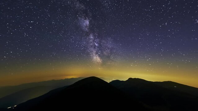 From night to day.Sky during a starry night with a milky galaxy of stars in the mountains.