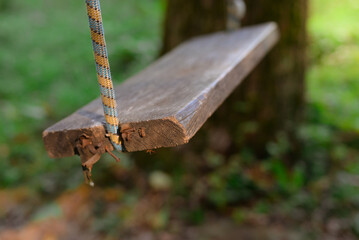 Wooden swing on ropes in the forest