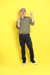 The 40s adult Asian man with casual dressed standing on the yellow background.