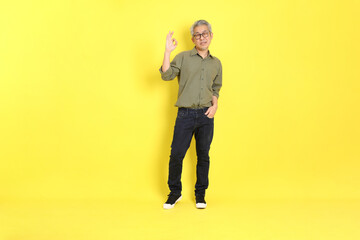 Fototapeta na wymiar The 40s adult Asian man with casual dressed standing on the yellow background.