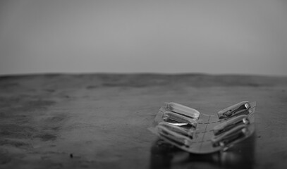 The last pill in the package. Metal surface. Copy space. Black and white. 