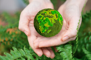 Woman holds a green planet Earth. Symbol of sustainable development and renewable energy	