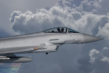 Fototapeta na wymiar RAF Typhoon Fighter Jet in Flight. Action photograph of Fast Jet military aeroplane on a combat mission. Used against Houthi Rebels