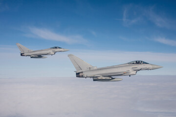 Typhoon Fighter Jet in Flight. Action photograph of Fast Jet military aeroplane on a combat mission air to air above the sea. a pair of fighter jets on a long range combat air patrol
