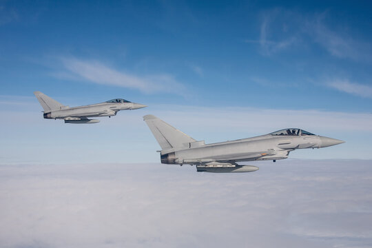 Typhoon Fighter Jet in Flight. Action photograph of Fast Jet military aeroplane on a combat mission air to air above the sea. a pair of fighter jets on a long range combat air patrol
