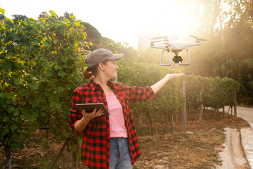 Woman farmer controls drone with a tablet. Smart farming and agriculture 4.0	