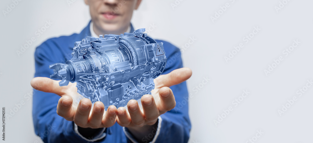 Poster Development engineer holds in his hands a model of an electric motor created in augmented reality.