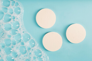 Three round pieces of white soap with foam - obrazy, fototapety, plakaty