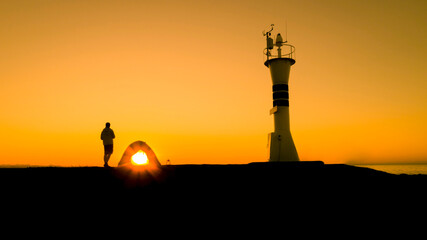 A man watching the sunset with his tent near the lighthouse. A man watching the landscape alone, solitude and sunset. Ordu, Türkiye