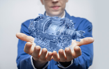 Development engineer holds in his hands a model of an electric motor created in augmented reality.