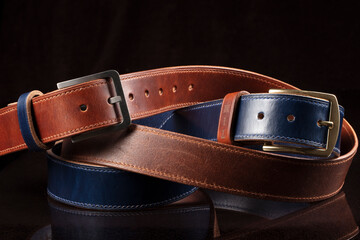 Leather belts on a black background. Haberdashery.