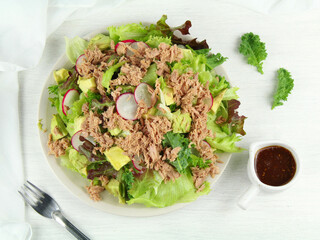 Tuna and green lettuce salad with fresh vegetables isolated on white background.